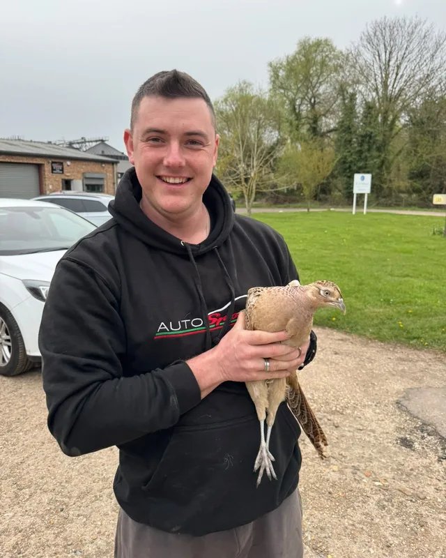 Dan holding a pheasant outside the workshop